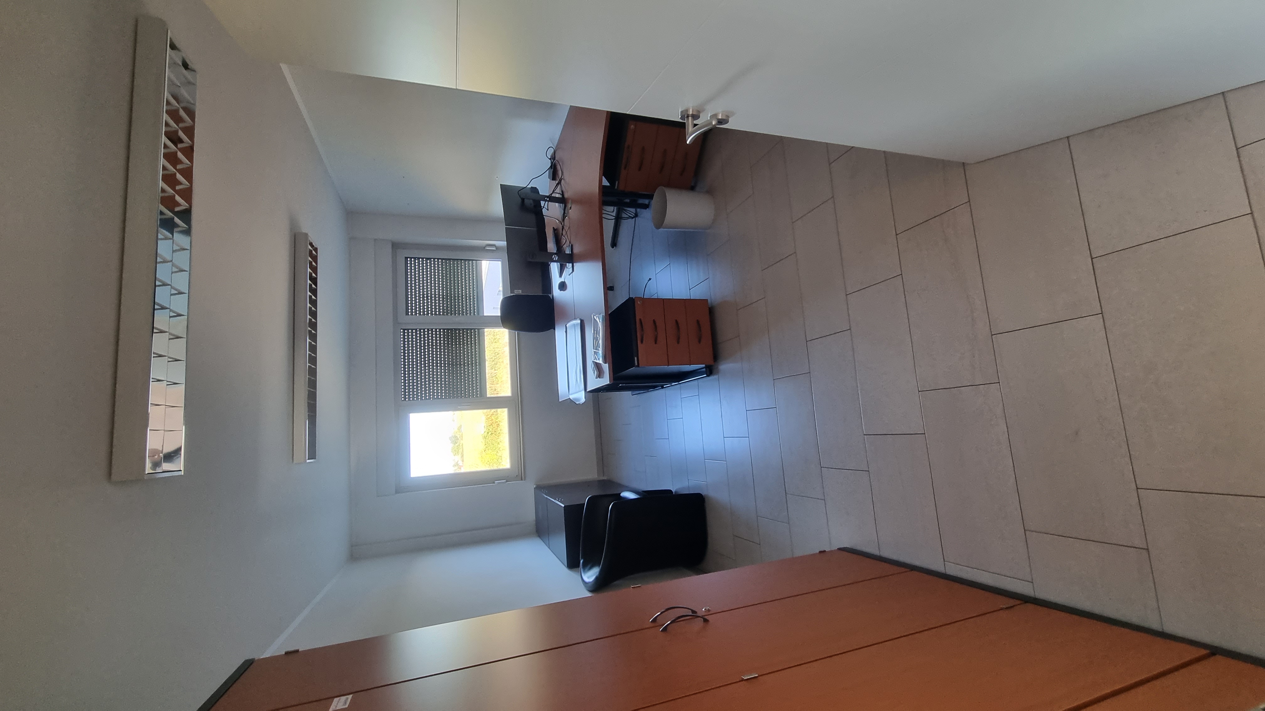 Büro mit breiter Fensterfront und Eckschreibtisch